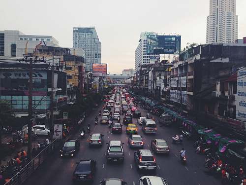 traffic jam assorted cars on asphalt road beside buildings road